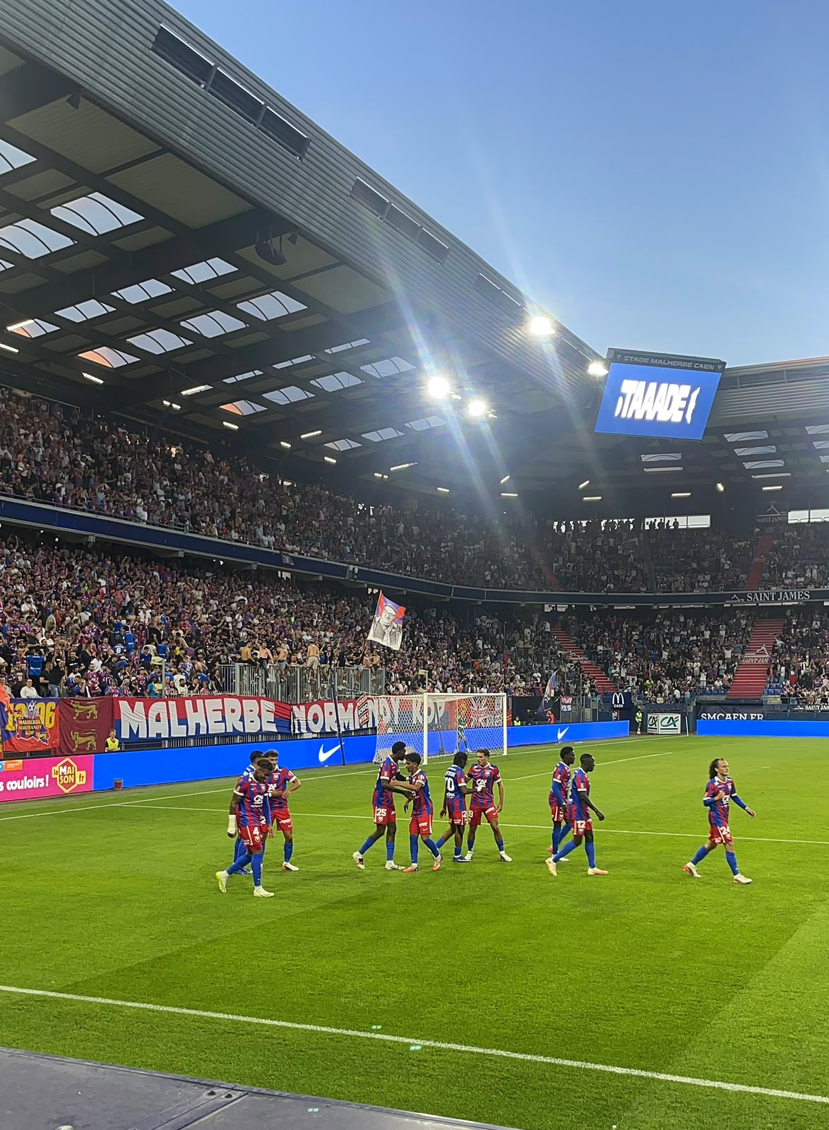 Joueurs de football célébrant un but devant les supporters